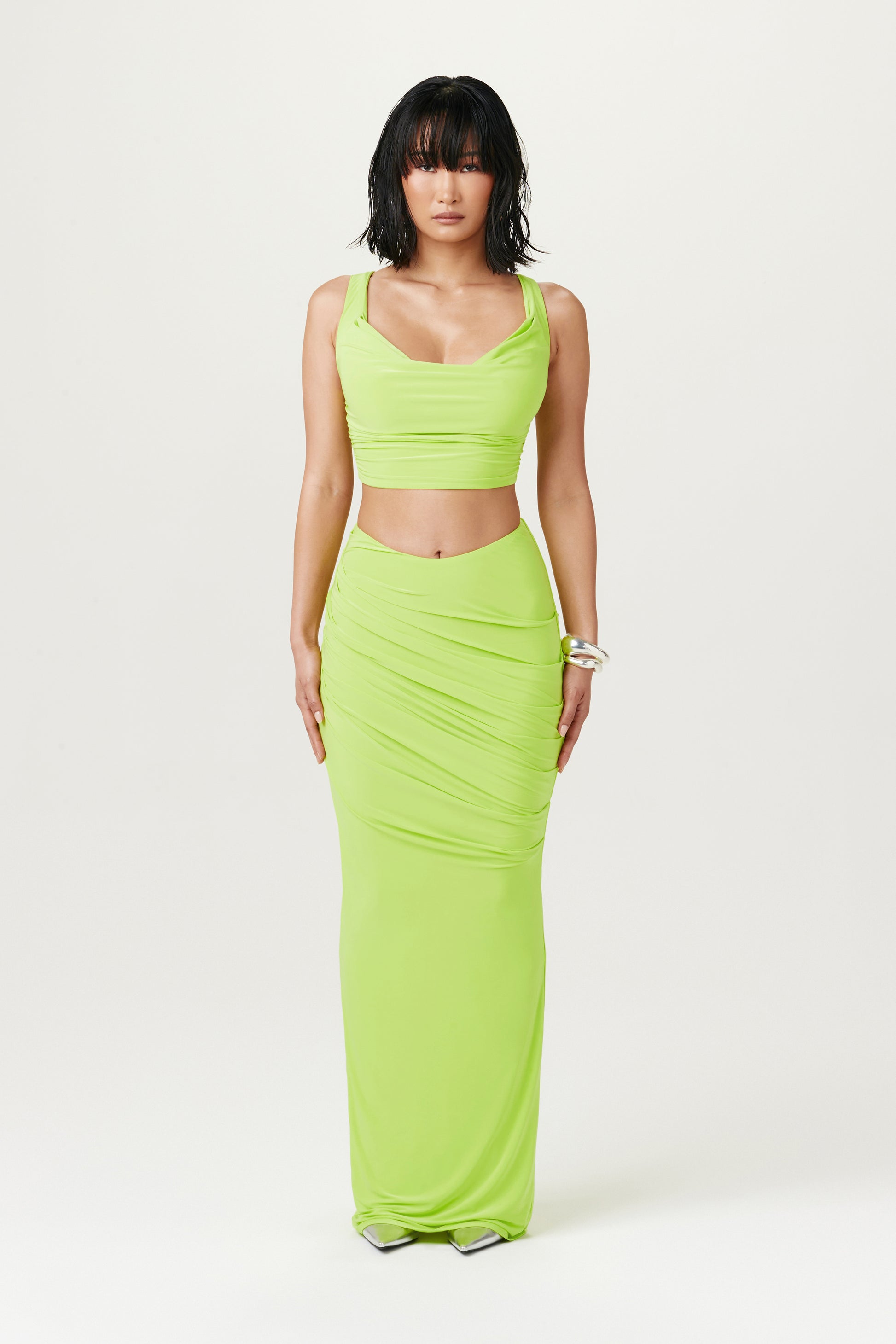 full body image of woman wearing lime green maxi skirt and matching crop top