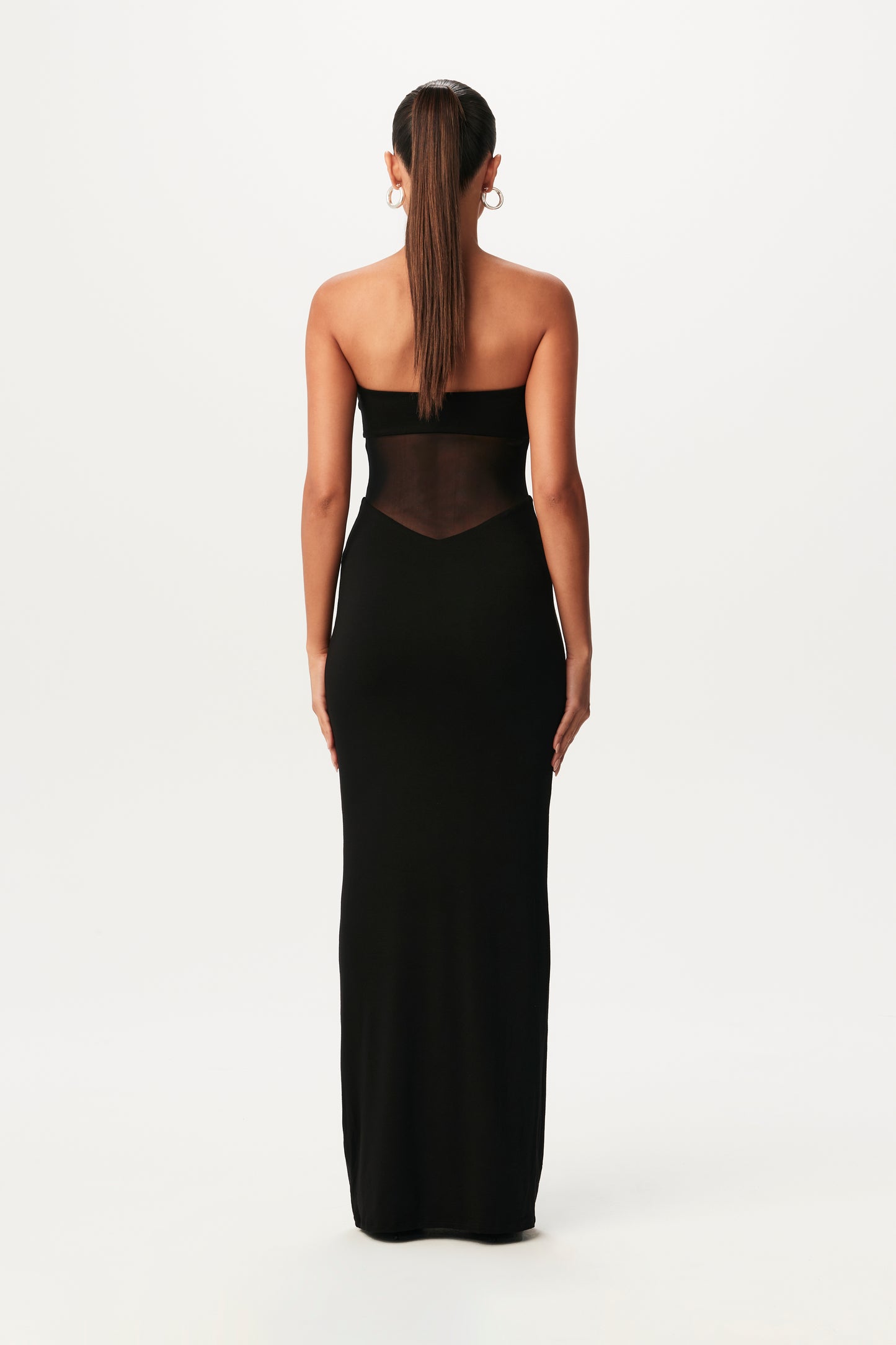 rear-view of black, strapless maxi dress with mesh cutout at waist
