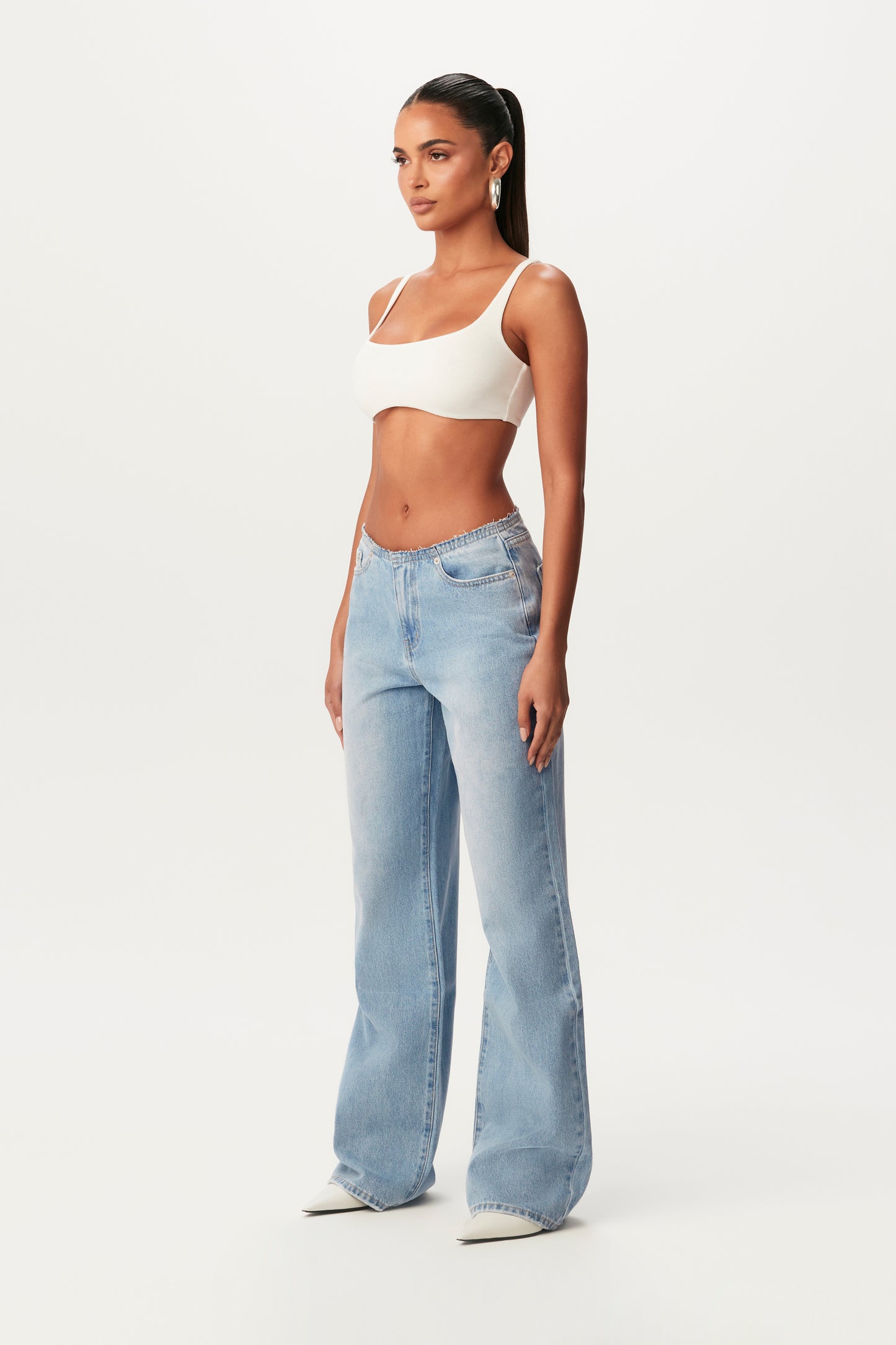 side view of white crop bra and denim jeans